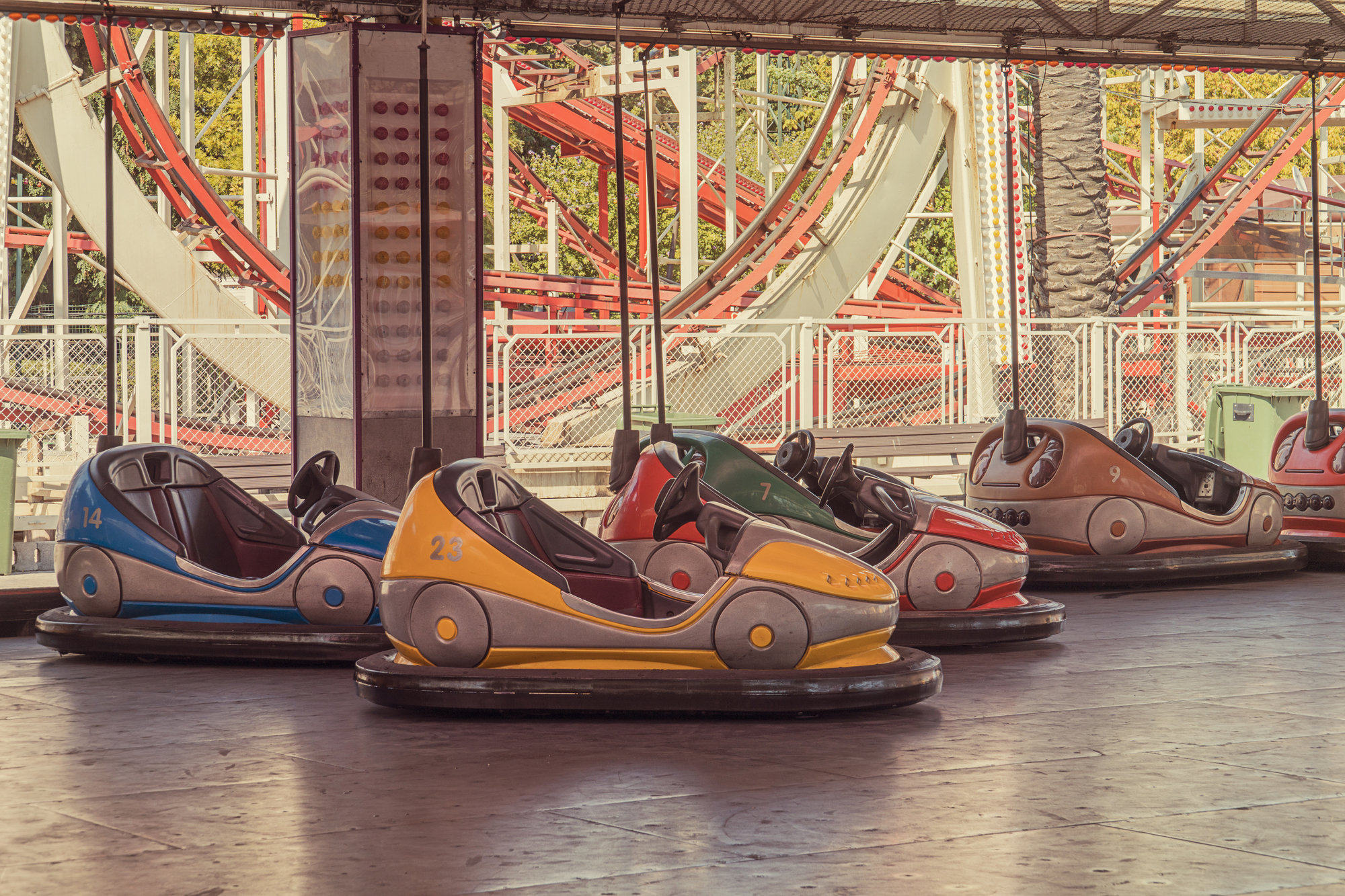 Bumper cars in front of a roller coaster
