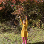 Girl doing a victory pose at the bottom of a hill