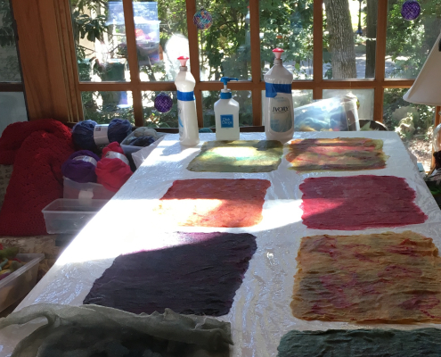 Colorful wool fibers, laid out, wet and ready to felt.