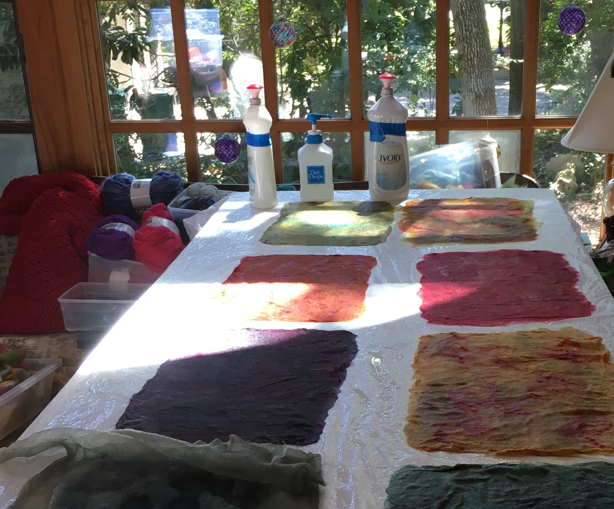 Colorful wool fibers, laid out, wet and ready to felt.