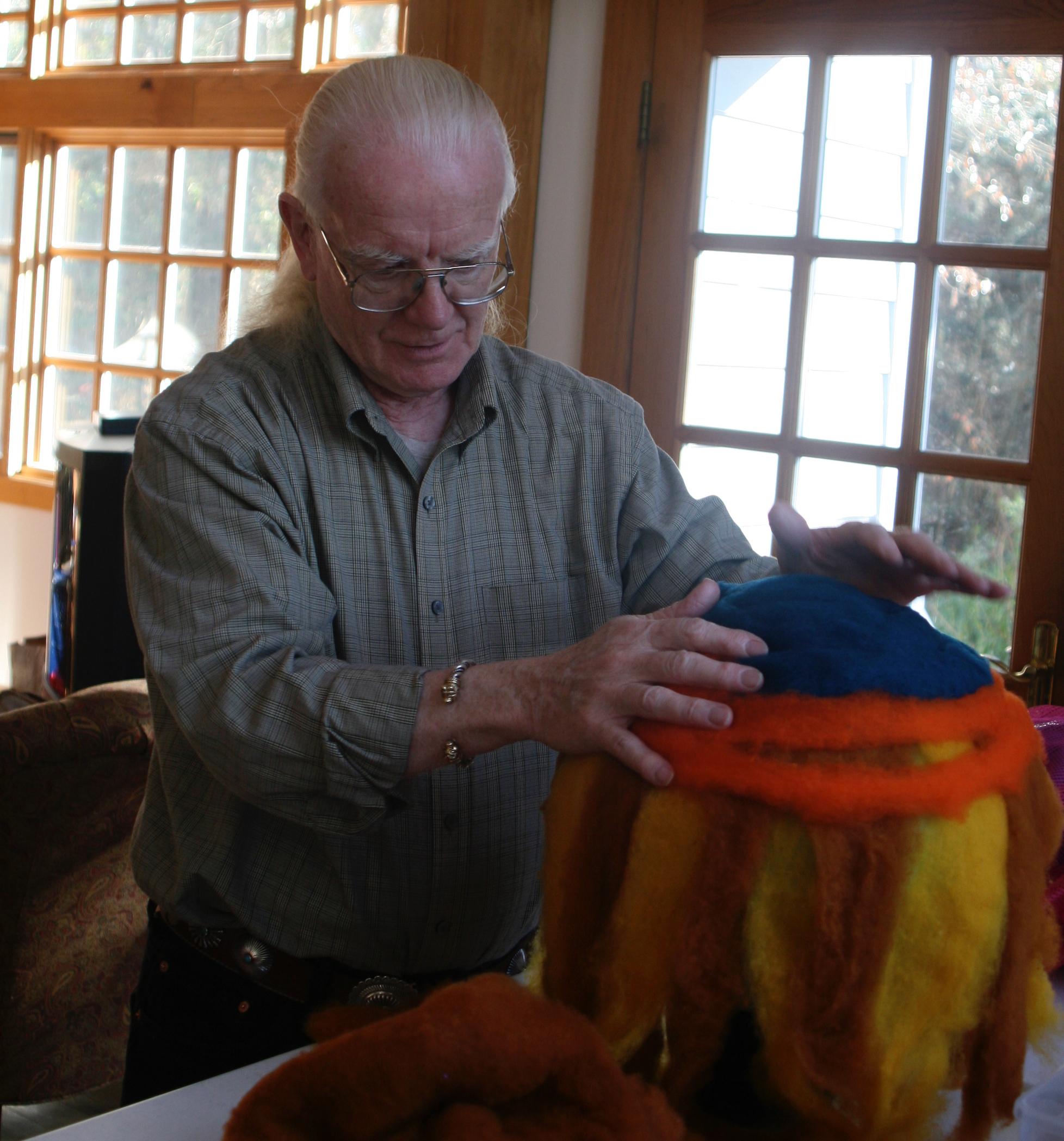 Man wrapping wool around a ball to make felt