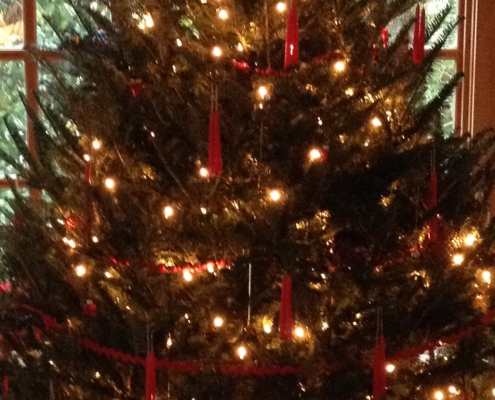 Christmas tree with white lights and red candles.