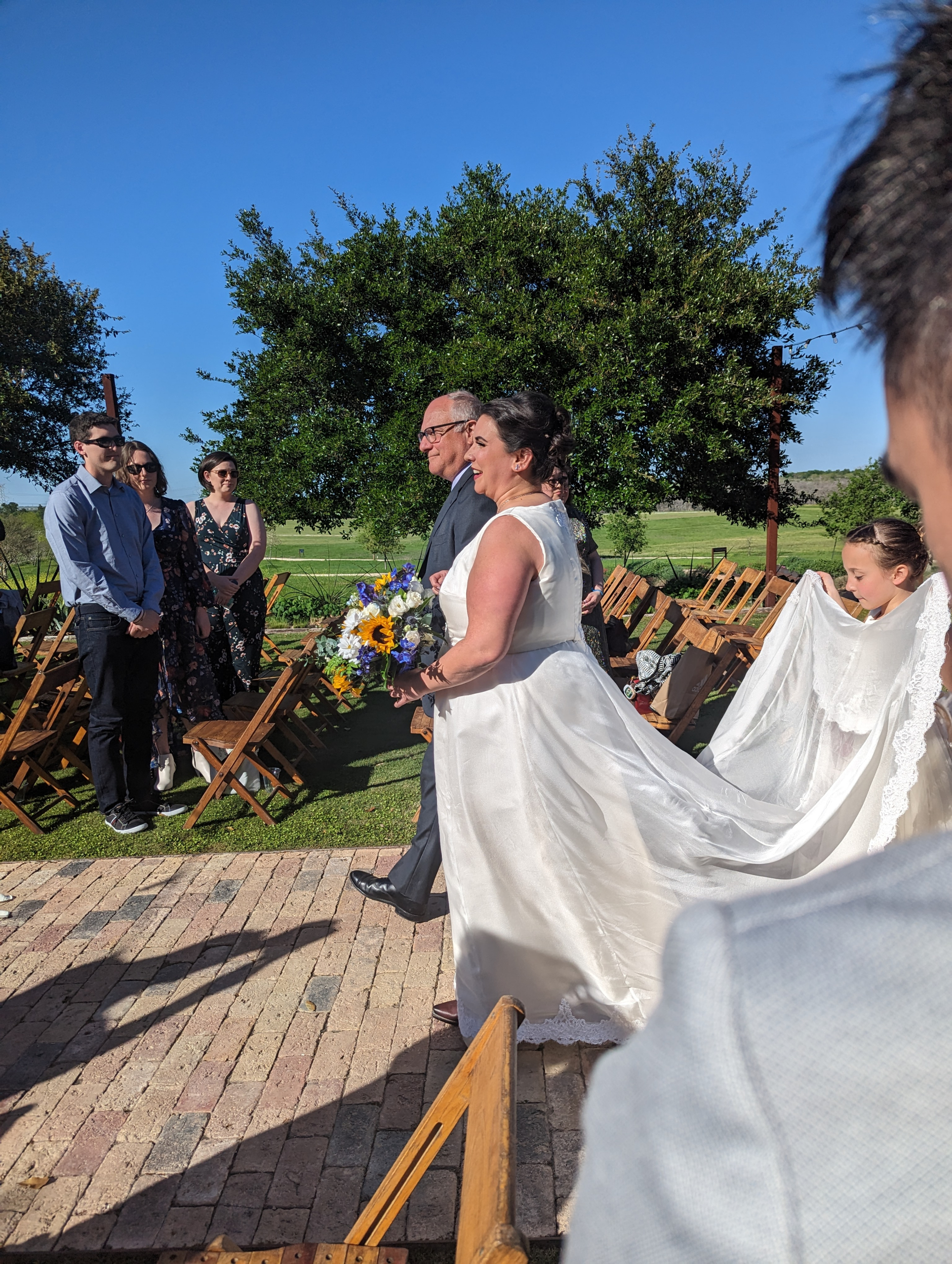 Bride, father, and flower girl walking down the aisle
