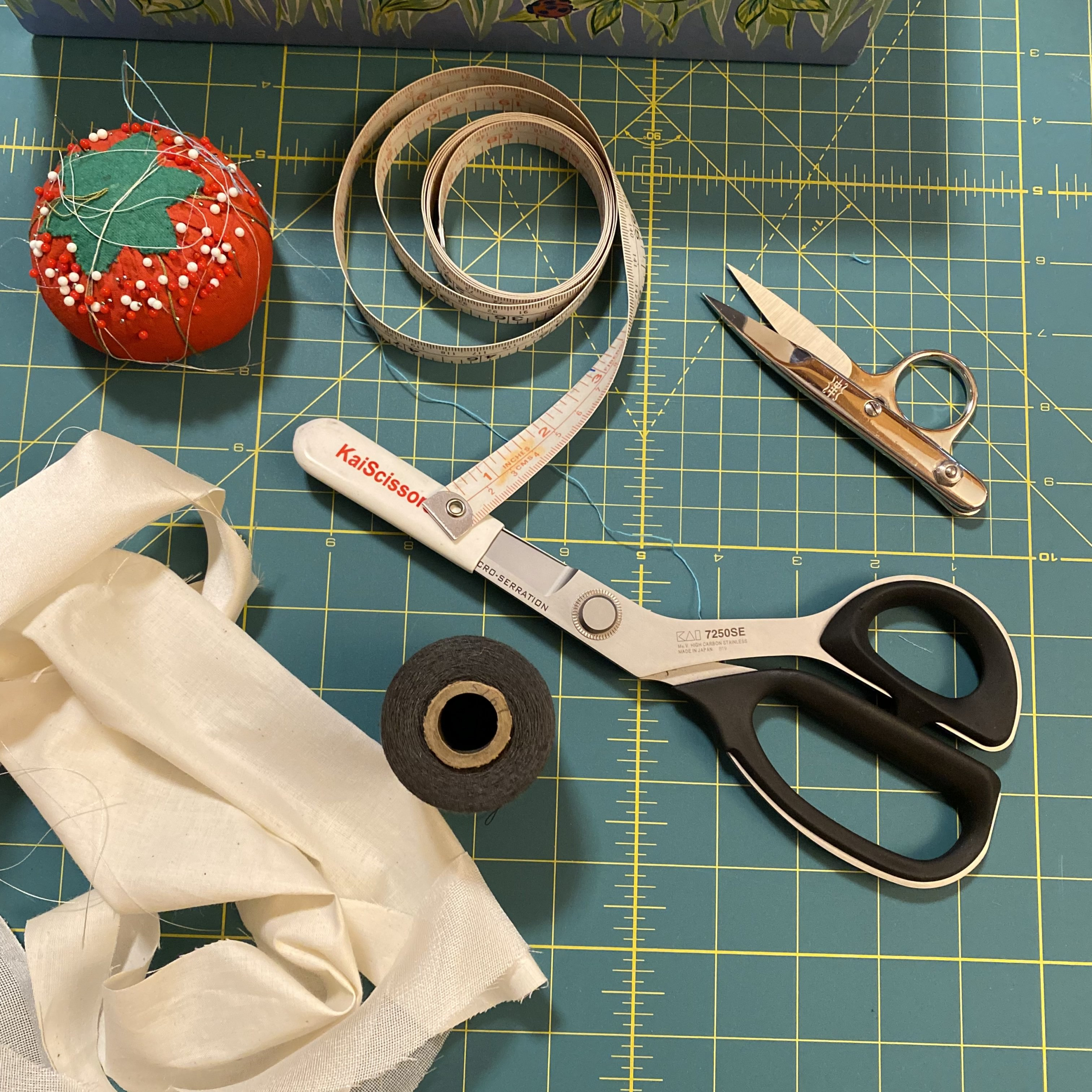 Sewing table with scissors, pin cushion, tape measure and fabric