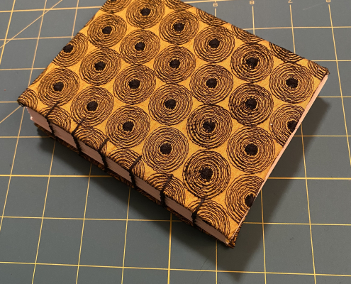 Hand-bound book, gold background with black circles