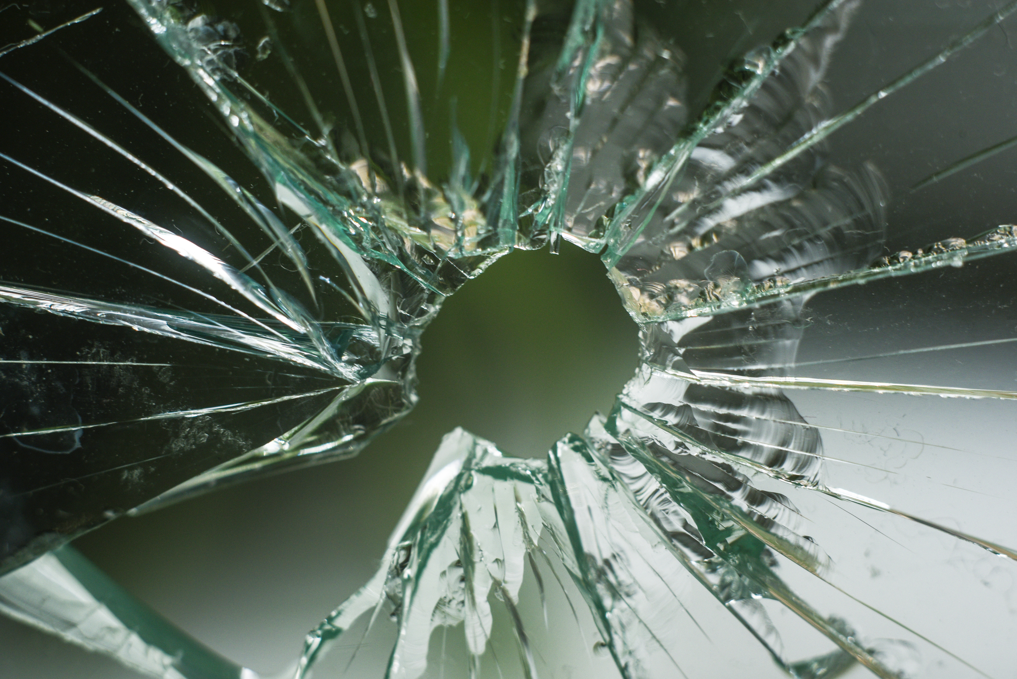 Bullet hole in center of shattered glass