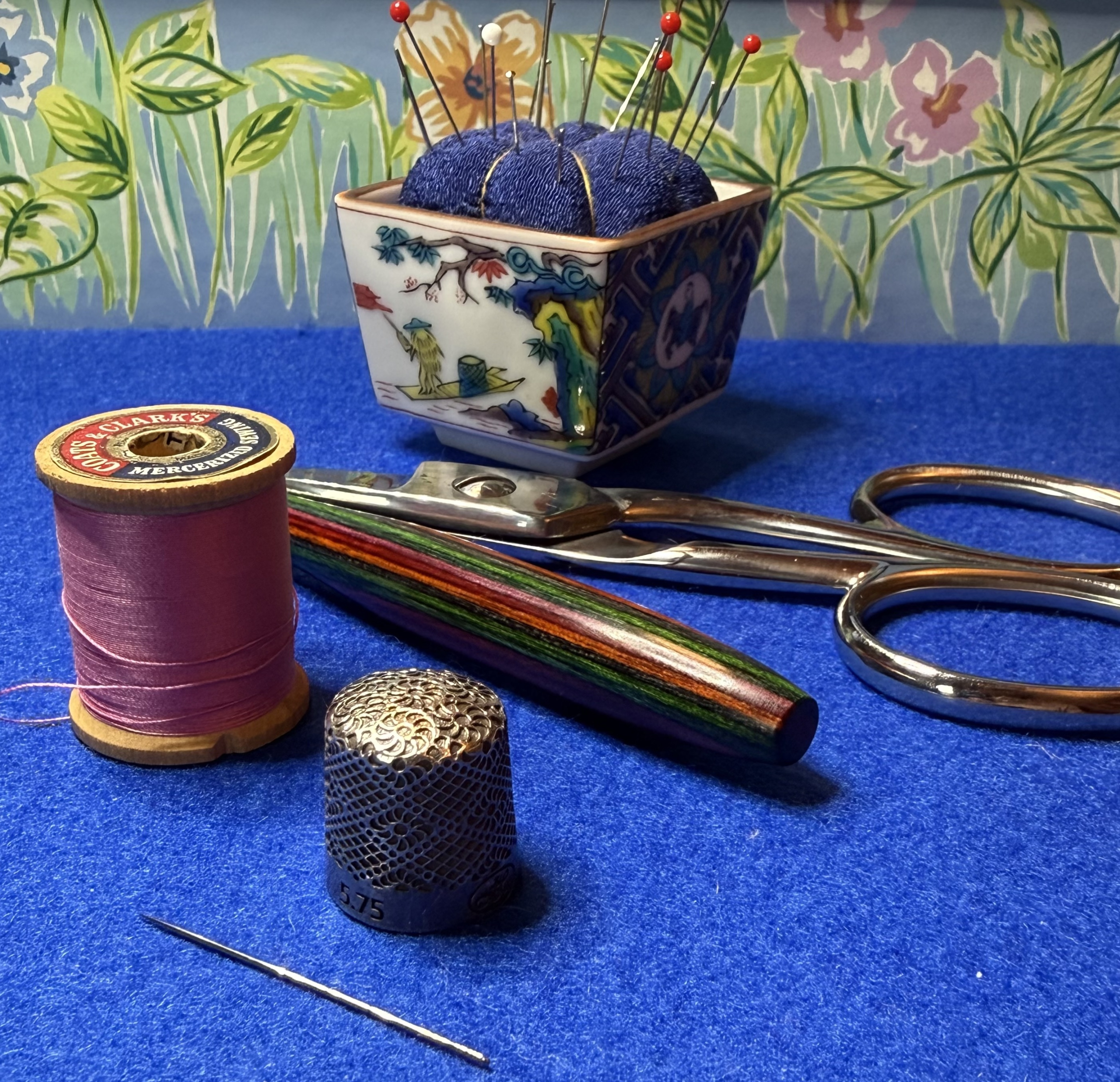 An assortment of small sewing tools on blue felt