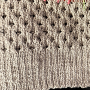 Light grey wool hand knit swatch, ribbing and an open work pattern